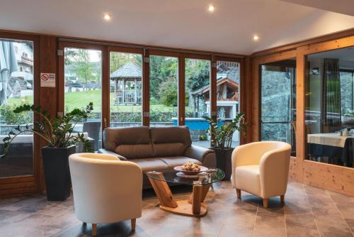 a living room with a couch and chairs and a table at Garni Residence Trocker in Castelrotto