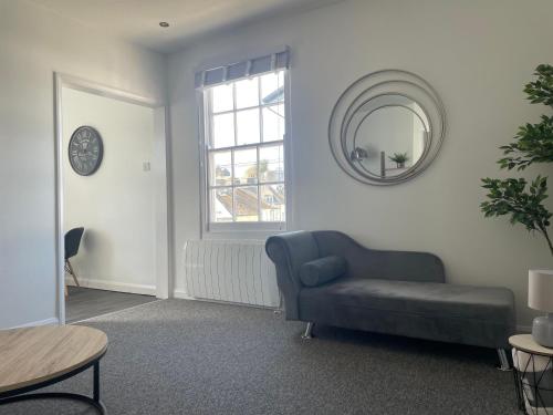 a living room with a blue couch and a mirror at Brownston Apartments in Modbury