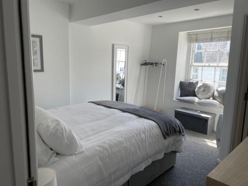 Habitación blanca con cama y ventana en Brownston Apartments en Modbury