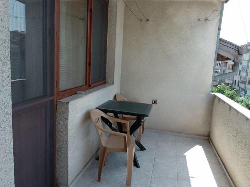 a small table and a chair on a balcony at Къща за гости Петрови in Primorsko