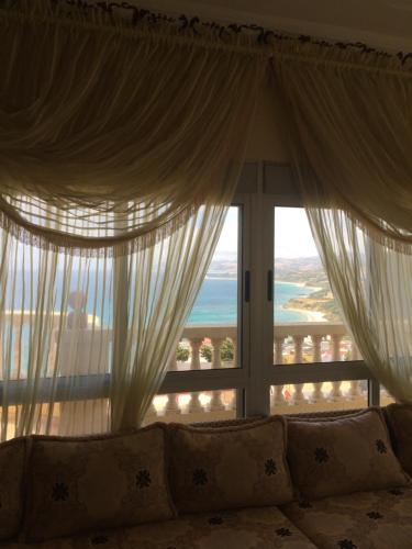 a living room with a couch in front of a window at Casa Dina in Tangier