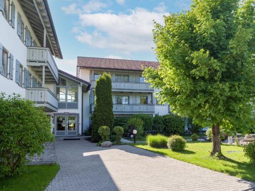 a large white building with a tree in front of it at Ferienwohnung Bergblick in Oberaudorf