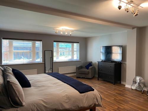 a bedroom with a bed and a flat screen tv at Riverside Townhouse, Only 20 Minutes from Brighton and Worthing in Shoreham-by-Sea