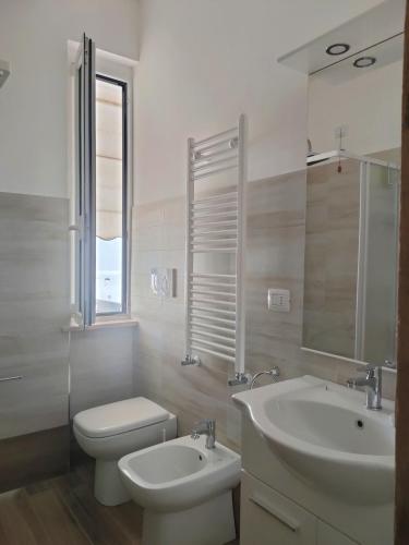 a white bathroom with a toilet and a sink at La Cicala del Conero in Marcelli