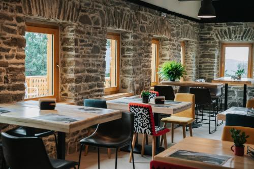 a restaurant with stone walls and tables and chairs at Cabana Fantanele in Ceahlău