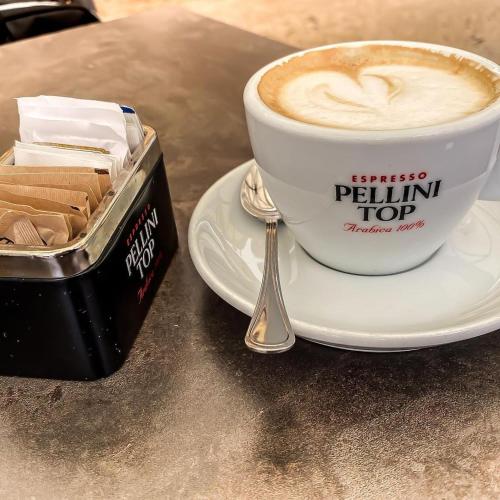 uma chávena de café num prato ao lado de uma caixa de bolachas em Il Borghetto em Lonigo