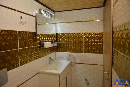 a bathroom with a sink and a mirror at Uzungöl Bungalow in Uzungol