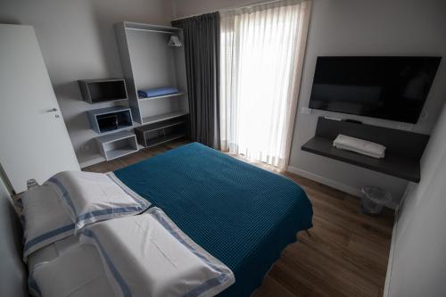 a small bedroom with a bed and a television at Relais del Garda in Lazise