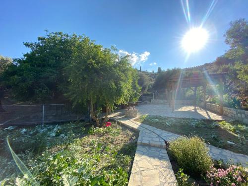 a garden with the sun in the sky at Villa Daskalogianni in Vlakhianá