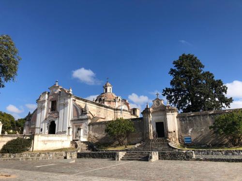 Une ancienne église avec des escaliers devant elle dans l'établissement URBANO TAJAMAR, à Alta Gracia
