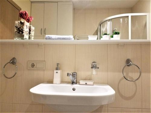 ein Badezimmer mit einem weißen Waschbecken und einem Spiegel in der Unterkunft Beautiful Apartment in the heart of Birstonas in Birštonas