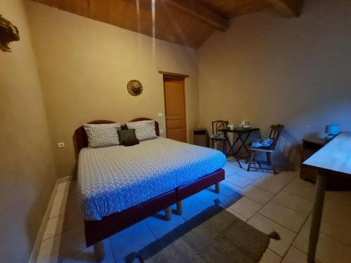 1 dormitorio con 1 cama con edredón azul en Chambres d'Hôtes Les Jourdets à l'Abri de l'Orée, en Lairière