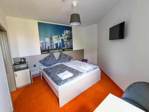 a small bedroom with a bed and a tv at Pension Berlin in Cheb