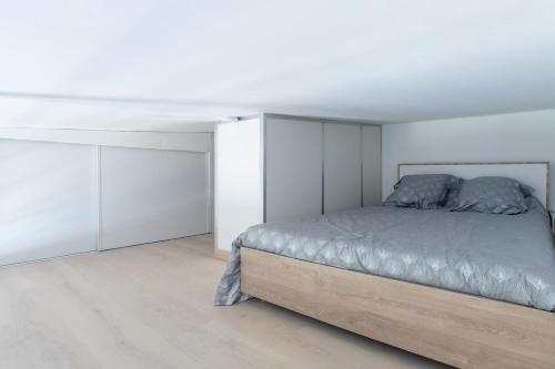 a white bedroom with a bed and white cabinets at Cosy Corner in Saint-Xandre