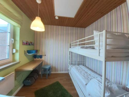 1 Schlafzimmer mit 2 Etagenbetten und einem Schreibtisch in der Unterkunft Ferienhaus Drosselgasse 8 in Berumbur
