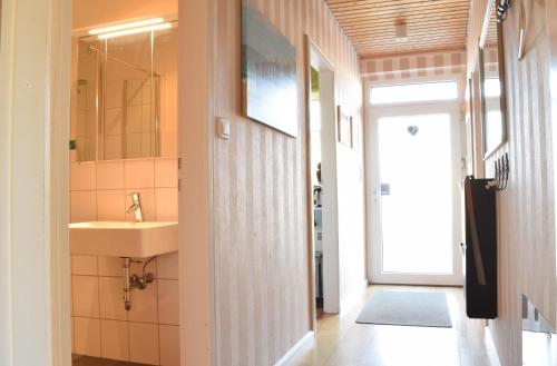 ein Bad mit einem Waschbecken und einem Spiegel in der Unterkunft Ferienhaus Drosselgasse 8 in Berumbur
