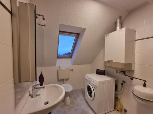 a bathroom with a sink and a washing machine at Ferienhaus Steuerbord im Bootshaus in Neßmersiel