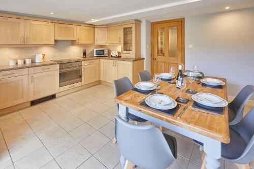a large kitchen with a wooden table and chairs at Host & Stay - River View in Masham