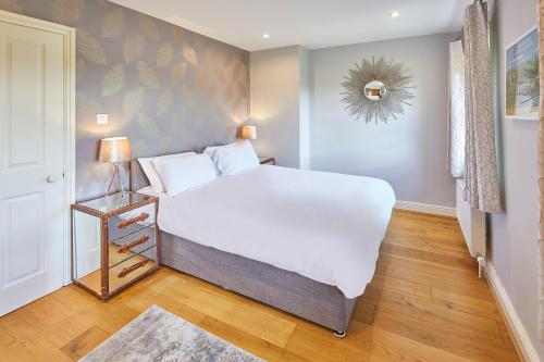 um quarto com uma grande cama branca e um espelho em Host & Stay - River View em Masham