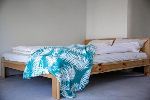 a bed with a blue and white blanket on it at Plateliai Samogitia Barn in Plateliai