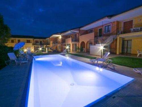 uma grande piscina em frente a uma casa à noite em Meridian 45 A3 em Peschiera del Garda
