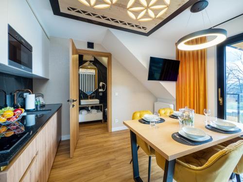 a kitchen and dining room with a table and chairs at Aparthotel Góralski Spa 2 in Białka Tatrzanska