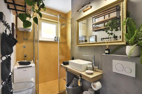 een badkamer met een wastafel en een spiegel bij Place to be - Center apartment in Pula
