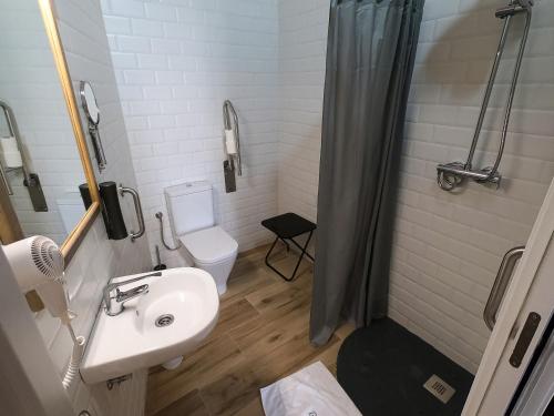 a bathroom with a sink and a toilet and a shower at Balhondo Open Village in Puebla de Alcocer
