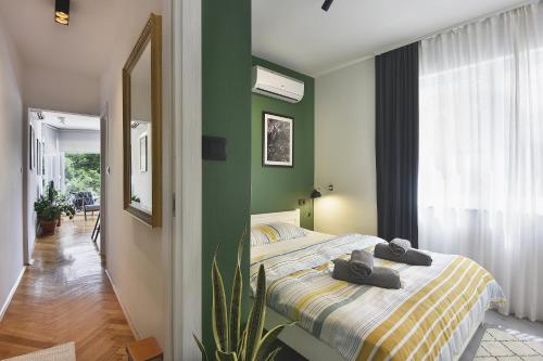 een slaapkamer met een bed en een groene muur bij Place to be - Center apartment in Pula