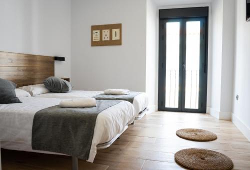 two beds in a room with two mats on the floor at Balhondo Open Village in Puebla de Alcocer