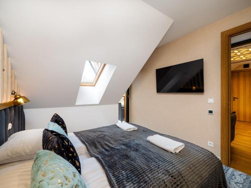 a bedroom with a bed with a tv on the wall at Aparthotel Góralski Spa 2 in Białka Tatrzanska