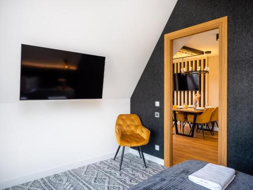a bedroom with a chair and a dining room at Aparthotel Góralski Spa 2 in Białka Tatrzanska