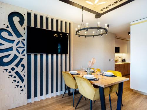 a dining room with a table and chairs and a tv at Aparthotel Góralski Spa 2 in Białka Tatrzanska