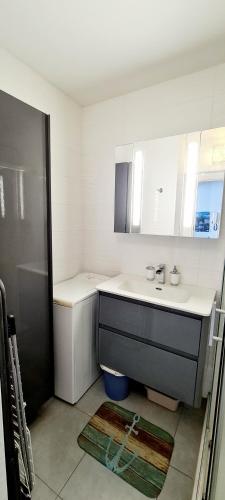 une salle de bain blanche avec un lavabo et une douche dans l'établissement Evasion Bleue, à Villeneuve-Loubet