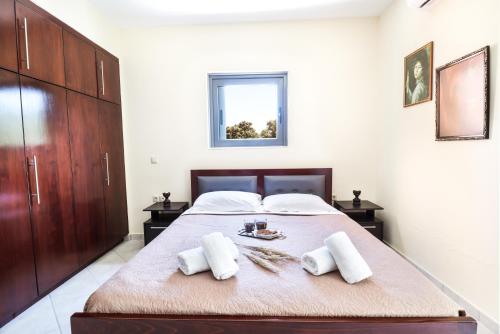 a bedroom with a large bed with two white towels at Korda's House in Ágios Prokópios