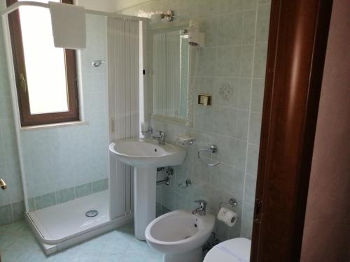 y baño con lavabo, aseo y espejo. en B&B L'antico borgo, en Villalago