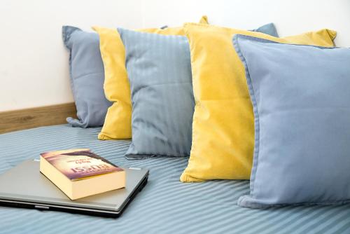 un libro sobre una cama con almohadas en Compact I - Faktura VAT, szybkie Wi-Fi, Netflix, niedaleko Centrum, en Koszalin