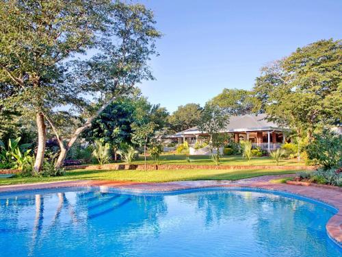 a swimming pool in front of a house at Pioneers in Victoria Falls