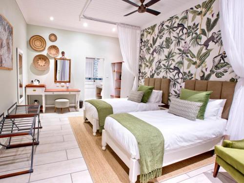 a bedroom with two beds and a desk at Pioneers in Victoria Falls