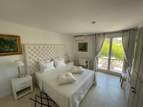 - une chambre avec un grand lit et un balcon dans l'établissement Villa Louise-Rose, à Villeneuve-Loubet