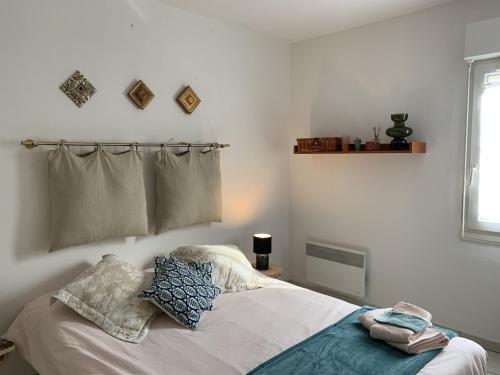 une chambre avec un lit avec deux oreillers dessus dans l'établissement Bel appartement à 100 mètres de la plage, à Nice