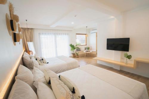 um quarto de hotel com duas camas e uma televisão de ecrã plano em Ultra Mint Dive Resort em Panglao