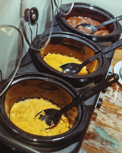 a group of four bowls of food with spoons in them at Hotel Areião in Goiânia