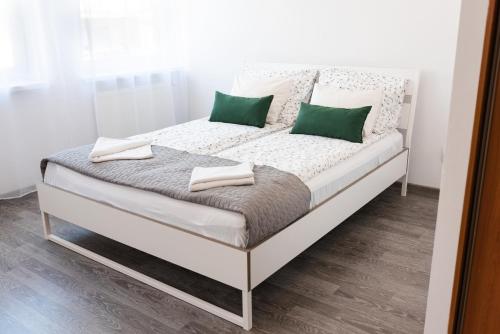 una cama con almohadas verdes en una habitación en Marcowy en Sopot