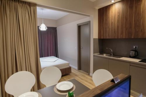 a hotel room with a bed and a table and chairs at Porta Apartament in Vlorë