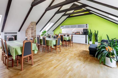 a dining room with green walls and tables and chairs at A.V.E. Pension Kliská in Prague