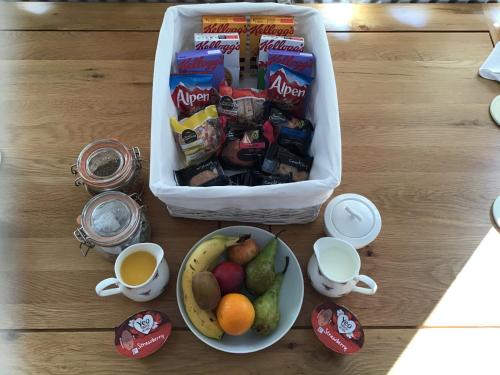 a table with a bag of snacks and a bowl of fruit at Old Chapel Forge in Chichester