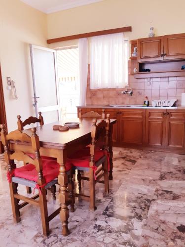 a kitchen with a wooden table and chairs at Sunny House in Vathí