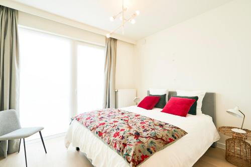 a bedroom with a large bed with red pillows at Diamant 1BR in Brussels