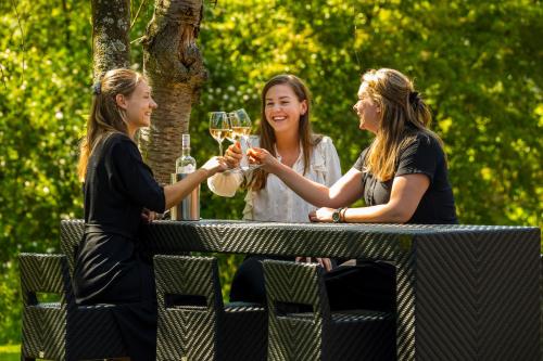 three women sitting at a picnic table drinking wine at Postillion Hotel Deventer in Deventer
